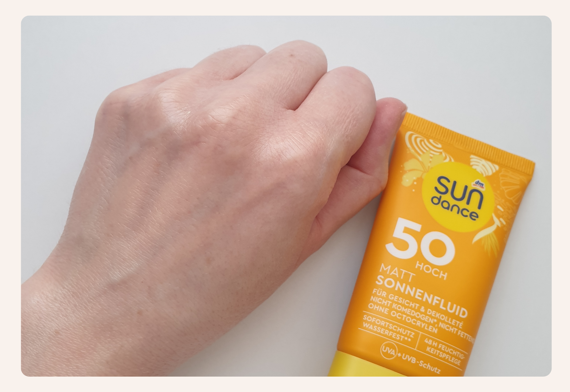 Spreading SUNdance 50 SPF sunscreen on hand, showing its transparent effect